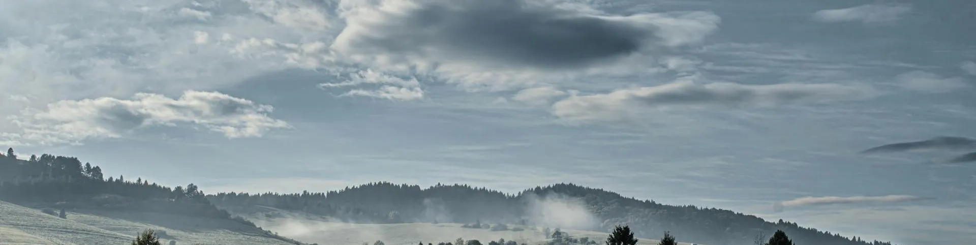 Misty rolling green hills at sunrise